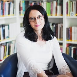 Dr Aneta Kochanowicz, specjalistka pedagogiki specjalnej, na tle regałów z książkami.