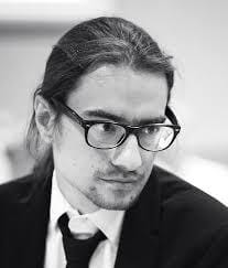 Dr Łukasz Stankiewicz w garniturze, zdjęcie czarno-białe, Uniwersytet Gdański.