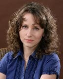 Na zdjęciu prof. dr hab. Agnieszka Gromkowska-Melosik z kręconymi włosami, w niebieskiej bluzce, patrzy w obiektyw.